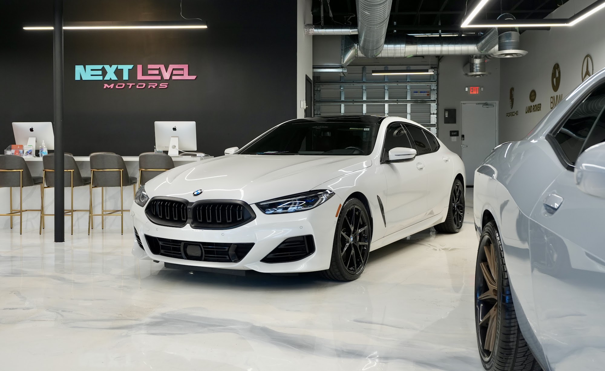 Reception desk beside a white BMW on the showroom floor